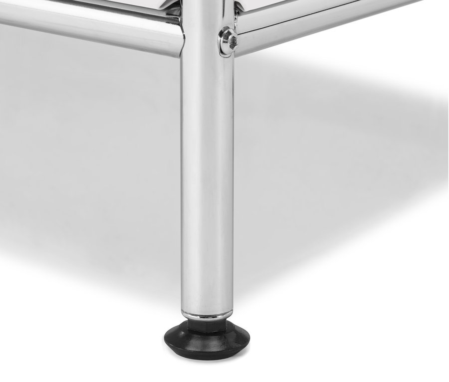 Zbliżenie na chromowaną nogę białej szafki.