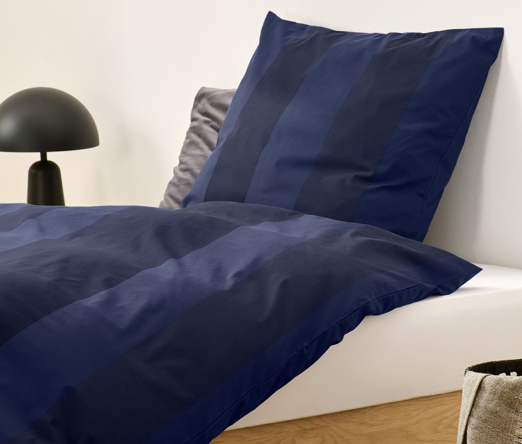 Niebieska pościel flanelowa w paski o standardowym rozmiarze na łóżku.