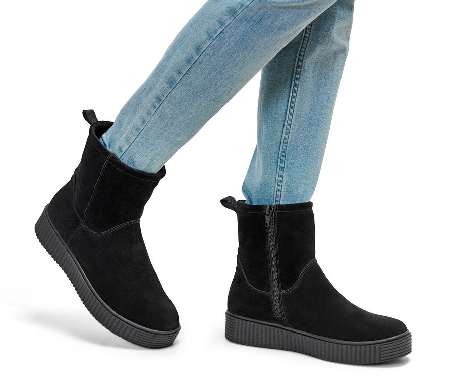 Nogi w jeansach i zamszowych botkach.