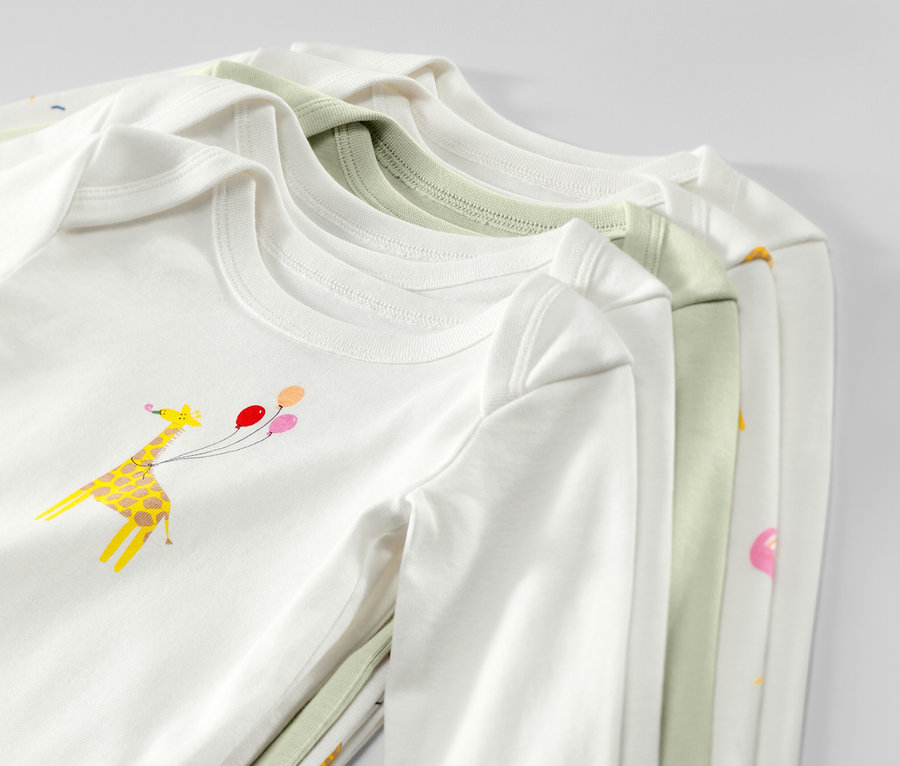 Zbliżenie na pięć body niemowlęcych rosnących z dzieckiem, z długim rękawem, w kolorze białym i jasnozielonym, z nadrukiem żyrafy z balonami.