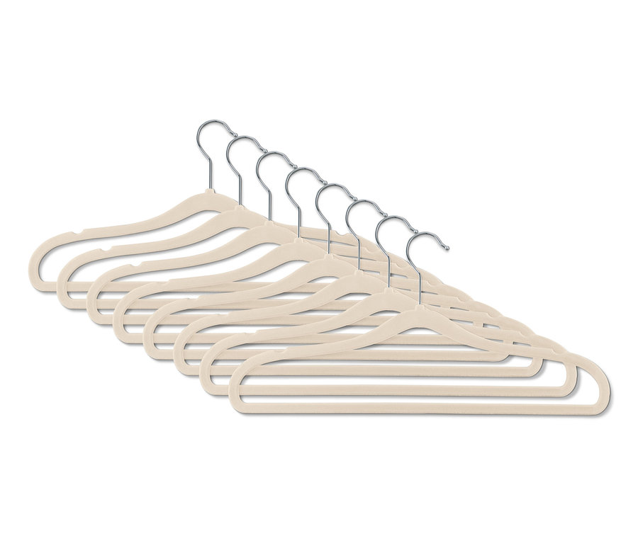 Osiem wyjątkowo wąskich wieszaków na ubrania w kolorze beżowym, ułożonych w rzędzie.