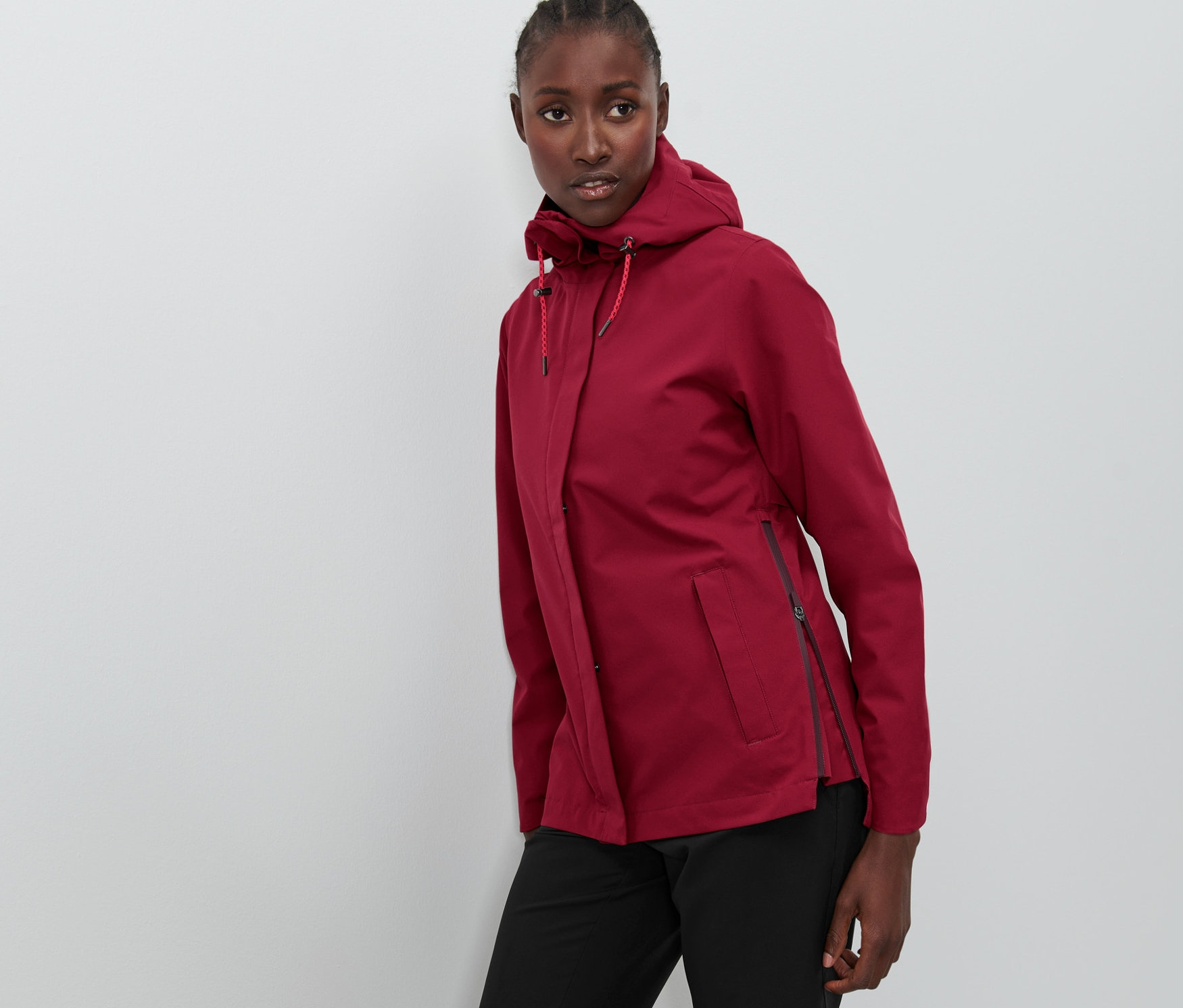 Kobieta pozuje w bordowej kurtce outdoorowej.