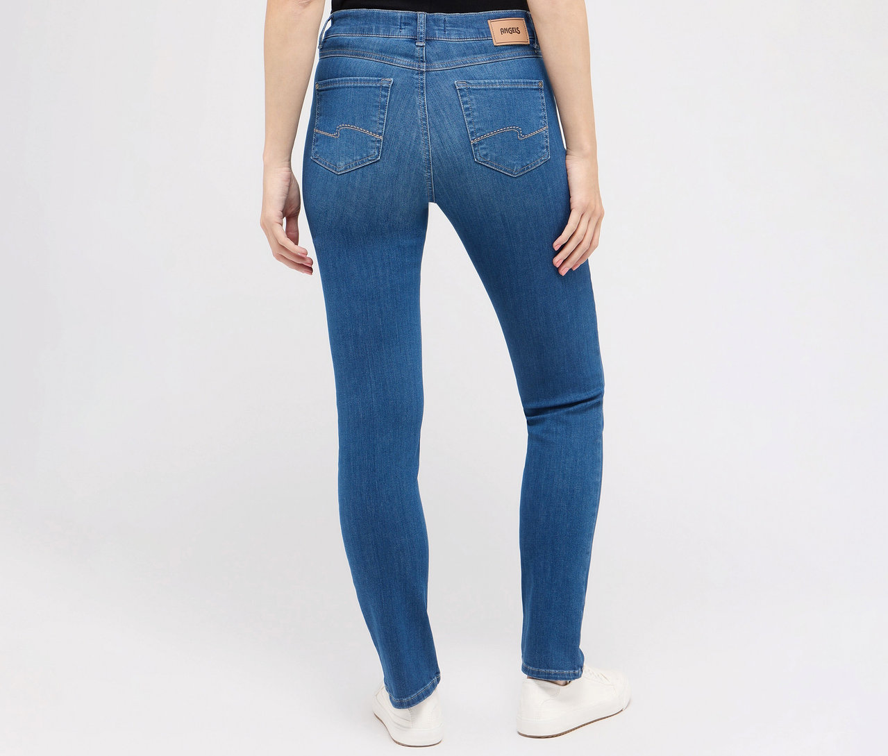 Widok z tyłu na kobietę ubraną w dżinsy Angels „Cici” Slim Fit, niebieskie i białe buty.