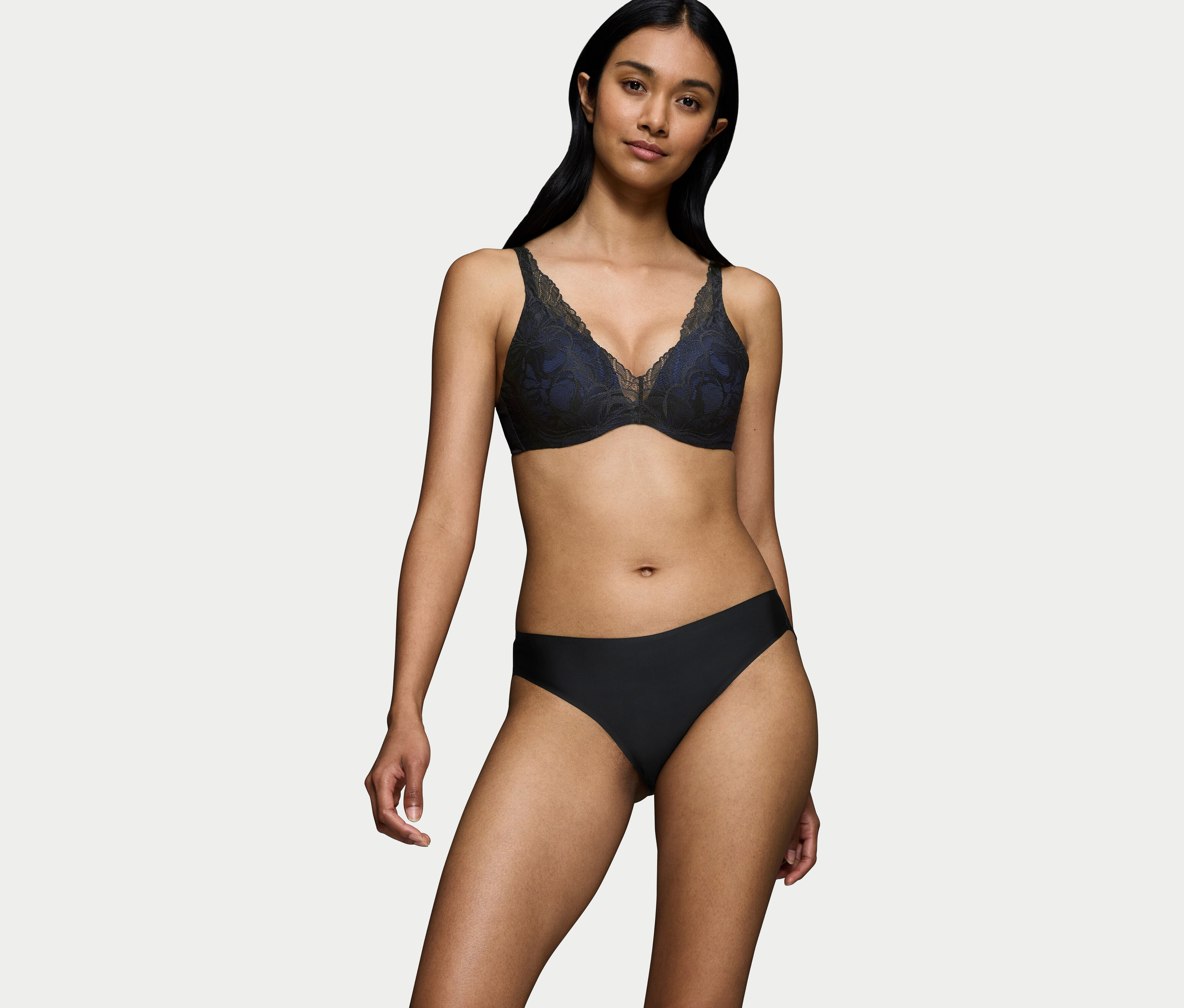 Kobieta ma na sobie czarny koronkowy biustonosz i czarne majtki.