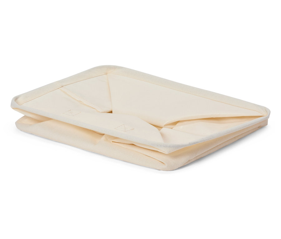 Złożony, kremowy pojemnik do przechowywania z tkaniny.