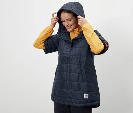 Kobieta poprawia kaptur w poncho outdoorowym.