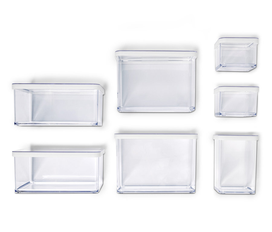 Siedem pustych, przezroczystych pojemników do przechowywania z białymi pokrywkami o różnych rozmiarach ułożonych na białym tle.