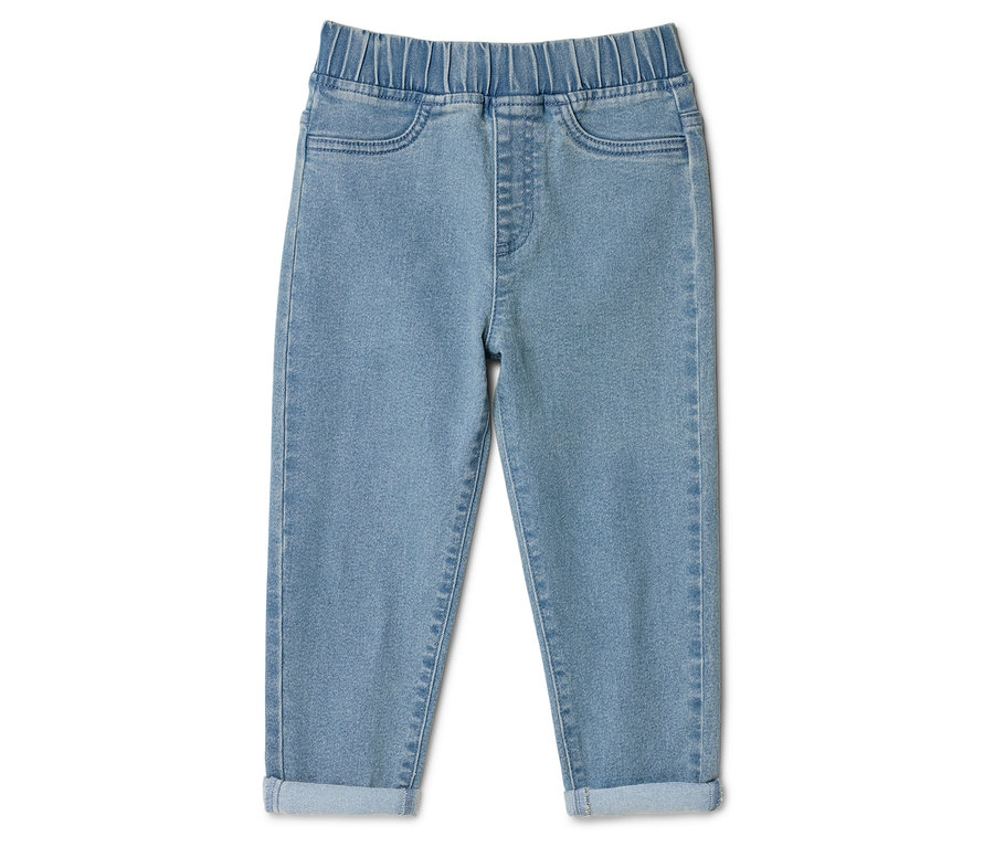 Jasne dżinsy ze ściągaczem w pasie i podwiniętymi nogawkami, leżące na białym tle.