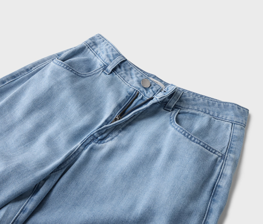Szczegółowy widok jasnoniebieskich dżinsów z widocznym zamkiem błyskawicznym i kieszeniami.