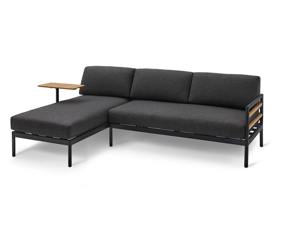 Szara sofa narożna z drewnianymi akcentami i małym stolikiem bocznym.