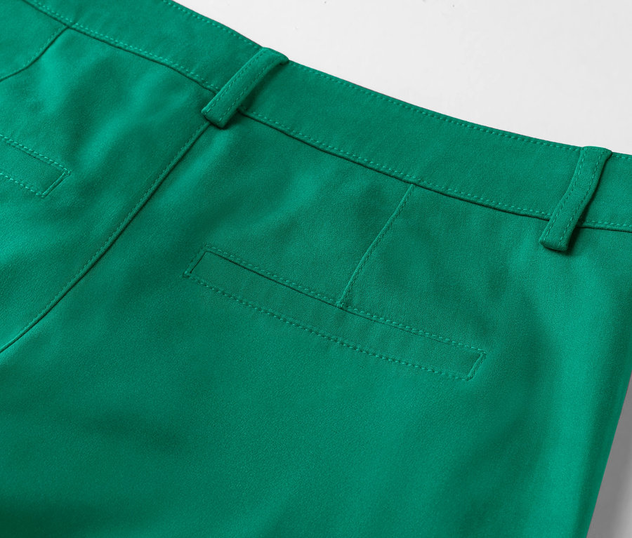 Zbliżenie na tył szmaragdowozielonych spodni z zaznaczoną kieszenią.