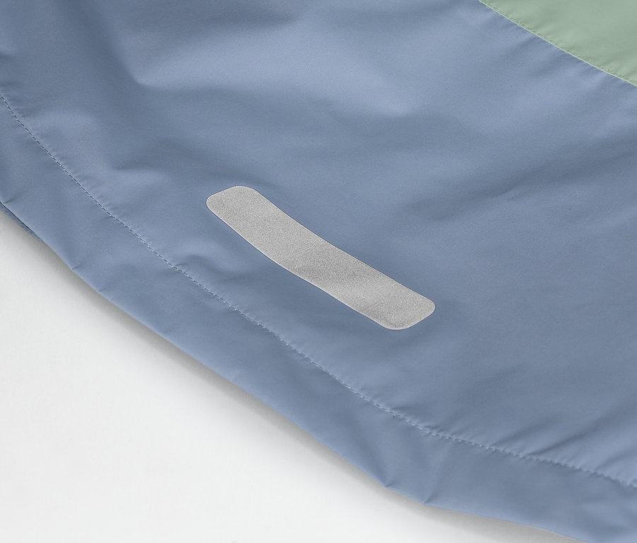 Szczegółowe ujęcie niebiesko-zielonej kurtki z odblaskowym paskiem z boku.