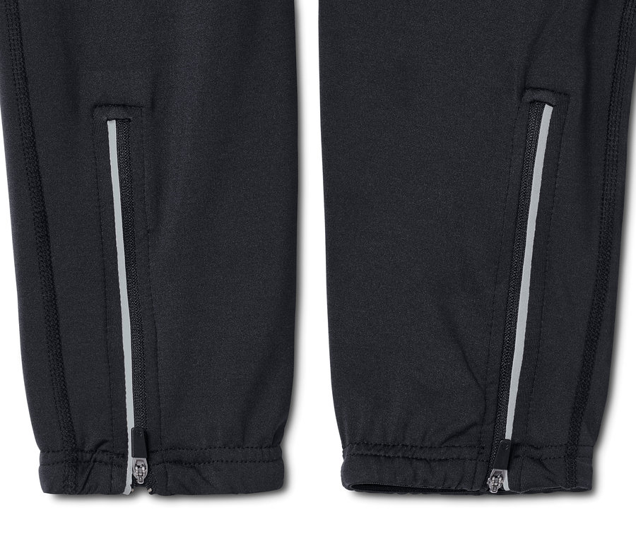 Szczegół spodni rowerowych z zamkami błyskawicznymi na nogawkach.