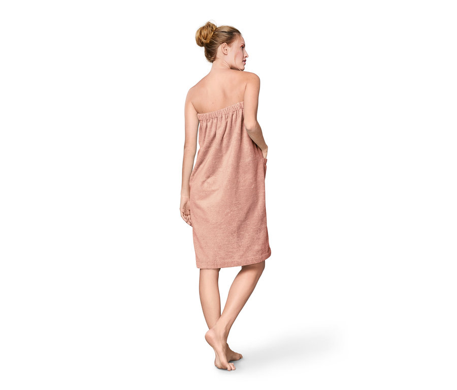 Kobieta tyłem, ubrana w kilt do sauny.