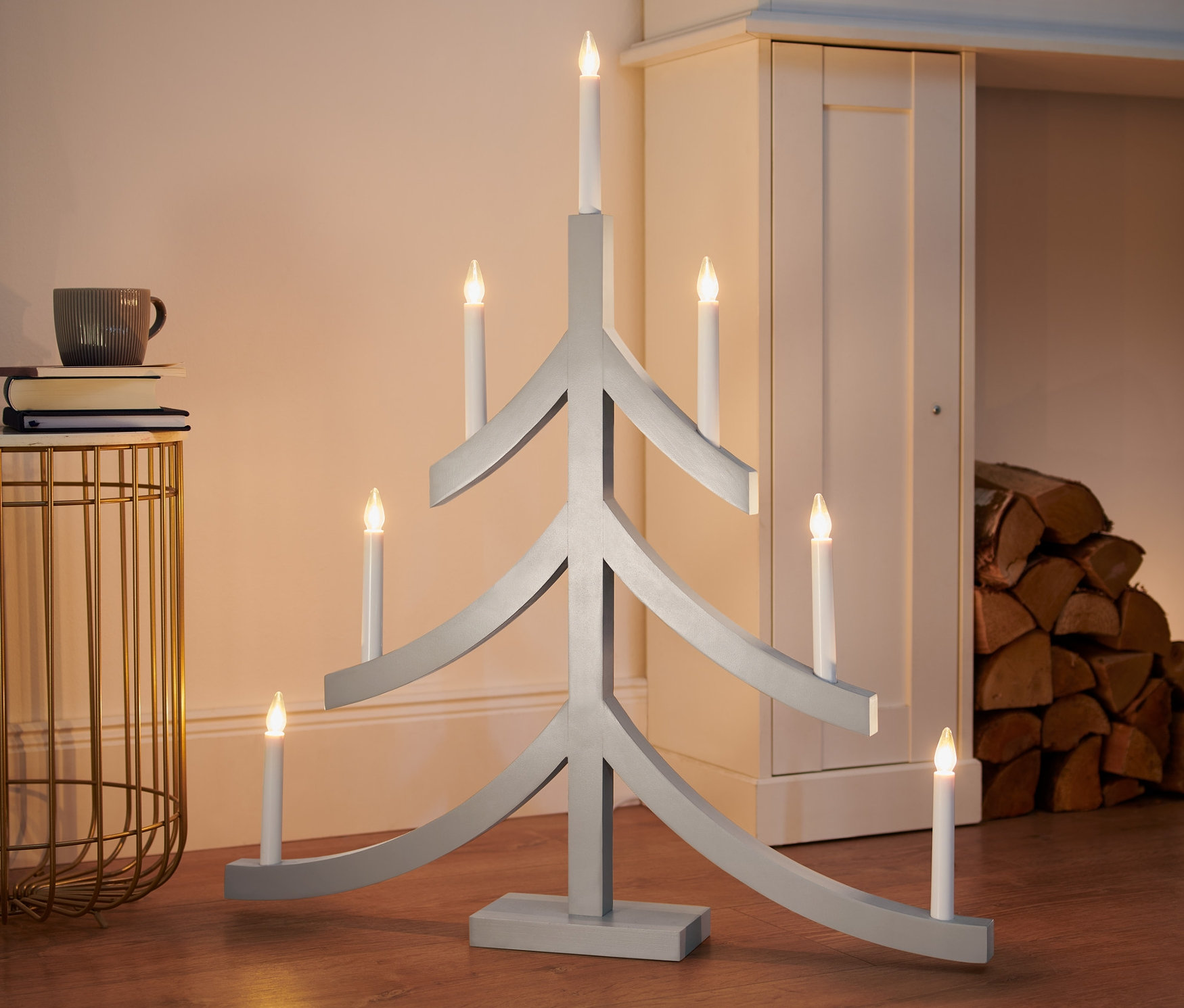 Szary świecznik LED XL w kształcie choinki stoi na podłodze.