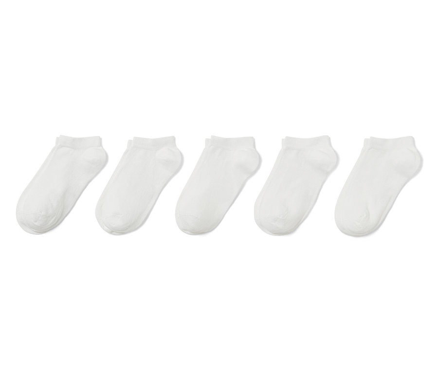 Pięć par białych skarpetek stopek dla dzieci leży obok siebie.