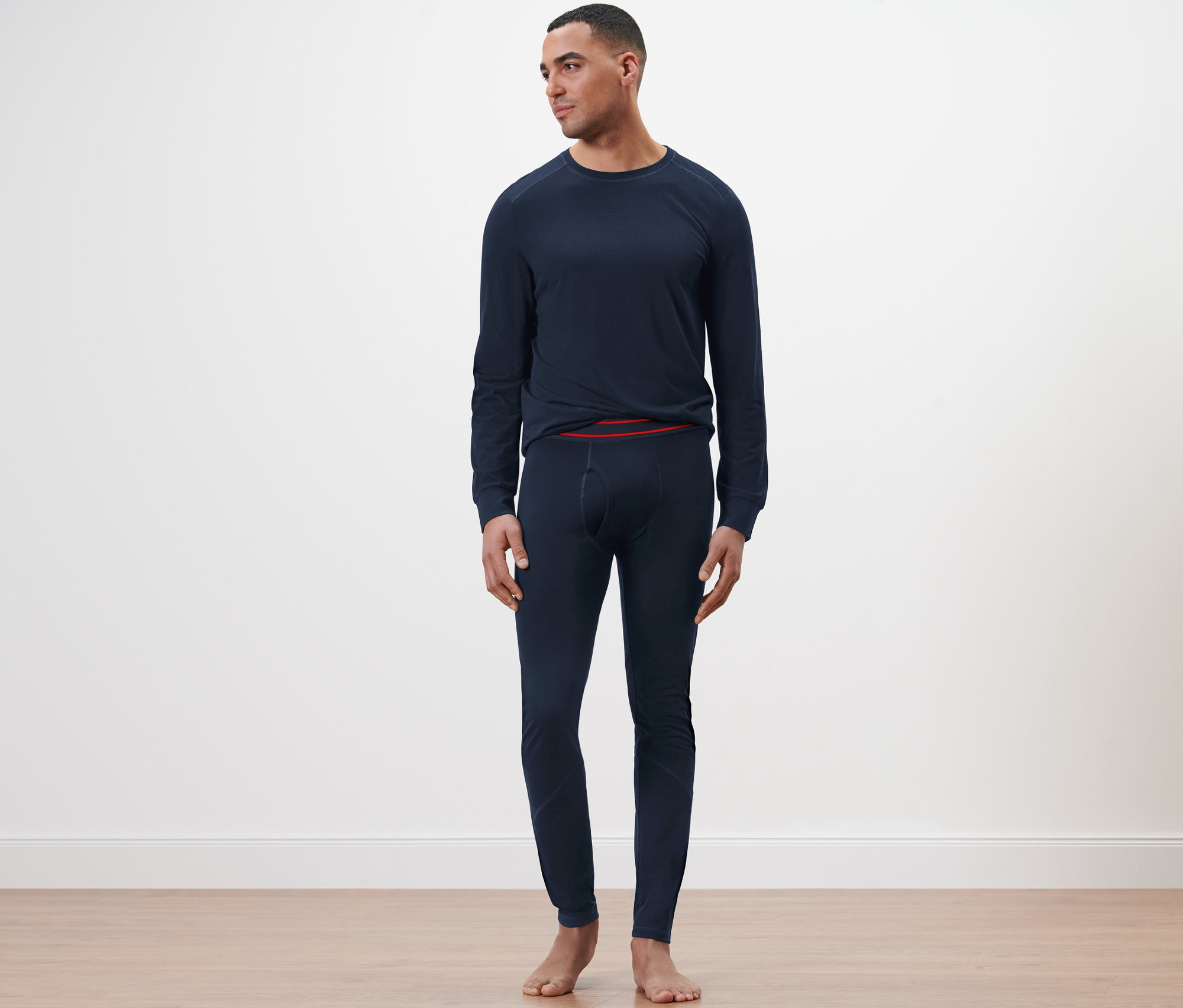 Mężczyzna stoi w granatowych długich kalesonach z wełny z certyfikatem RWS.