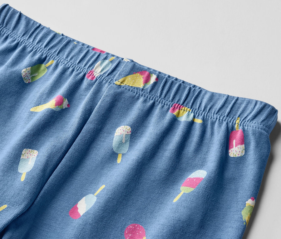 Zbliżenie na niebieskie legginsy dziecięce 3/4 z nadrukiem lodów.