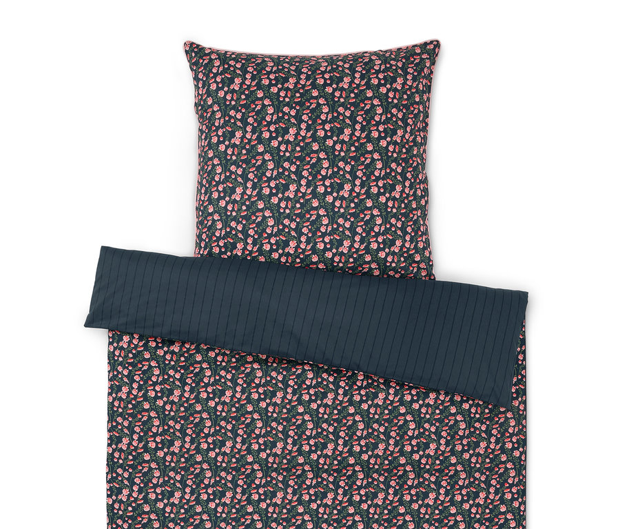 Pościel we wzory kwiatowe i jednobarwna poszewka na poduszkę.