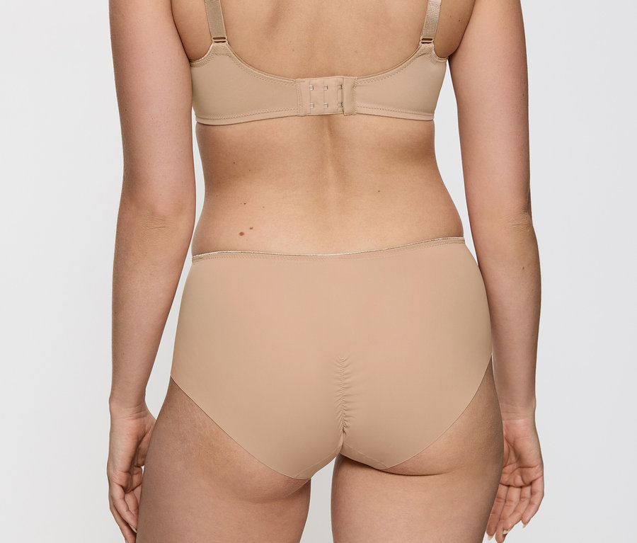 Widok z tyłu kobiety ubranej w cielisty biustonosz i majtki Triumph Essential „Minimizer W X”.