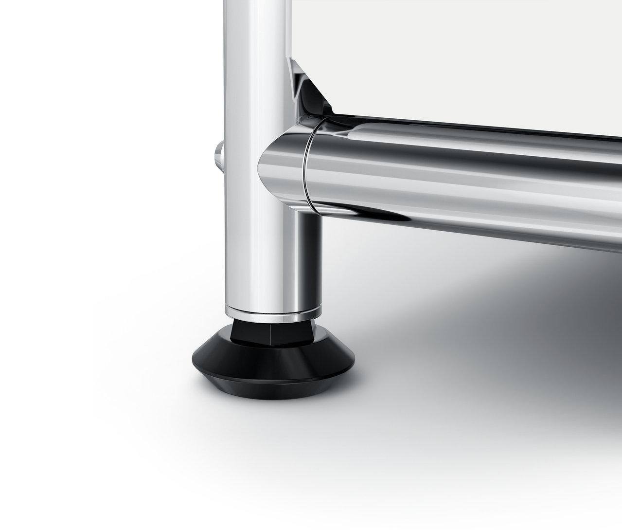 Szczegół chromowanej nogi mebla z czarną stopką.