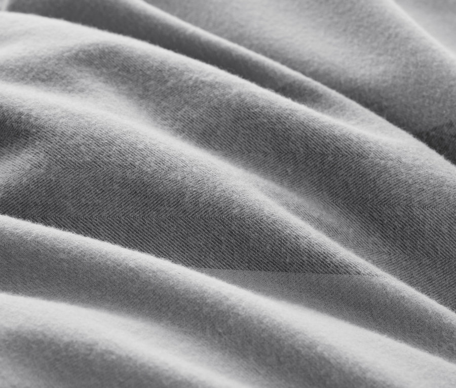 Zbliżenie na szarą tkaninę o teksturze i fałdach.
