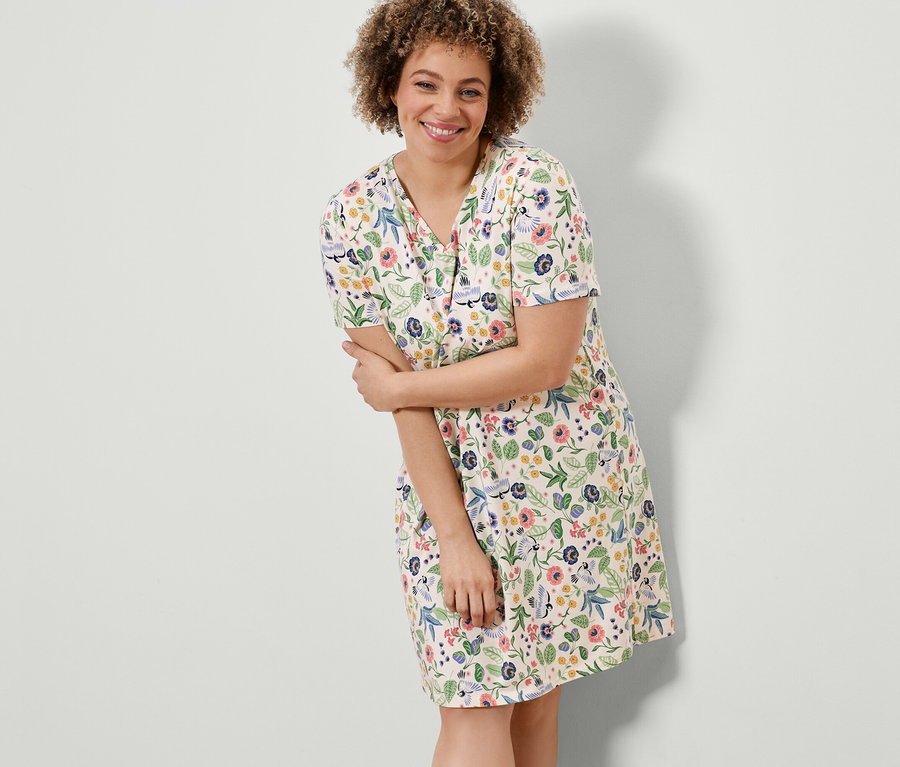 Kobieta pozuje w koszuli nocnej w kwiaty.