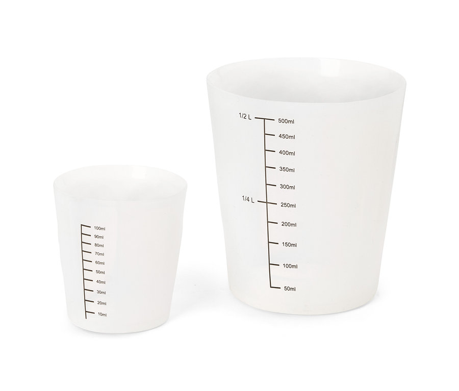 Dwa półprzezroczyste białe kubki miarowe, jeden mniejszy (10-100ml) i jeden większy (50-500ml, 1/4 L, 1/2 L).