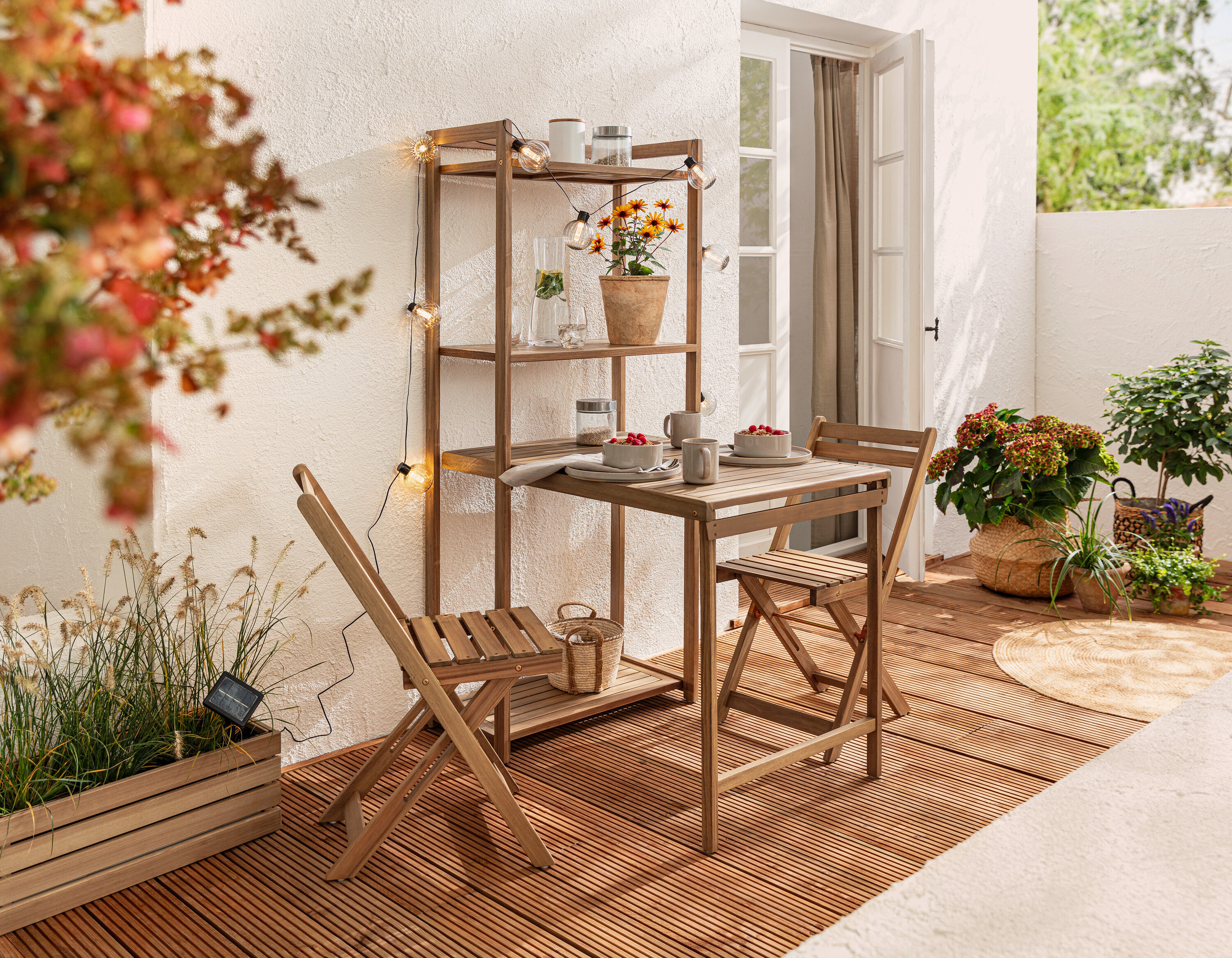 Zestaw na balkon „Lenja” z regałem i solarny łańcuch świetlny, rowkowane kule na balkonie.