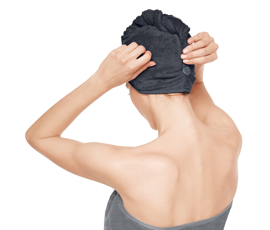 Kobieta poprawia turban do włosów na głowie.