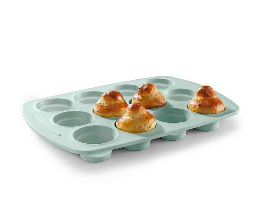 Cztery upieczone babeczki w miętowej silikonowej formie do muffinów.