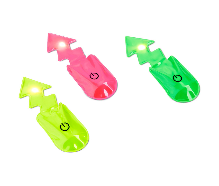 Trzy lampki LED z magnesem »Błyskawica« w różnych kolorach leżą na białym tle.