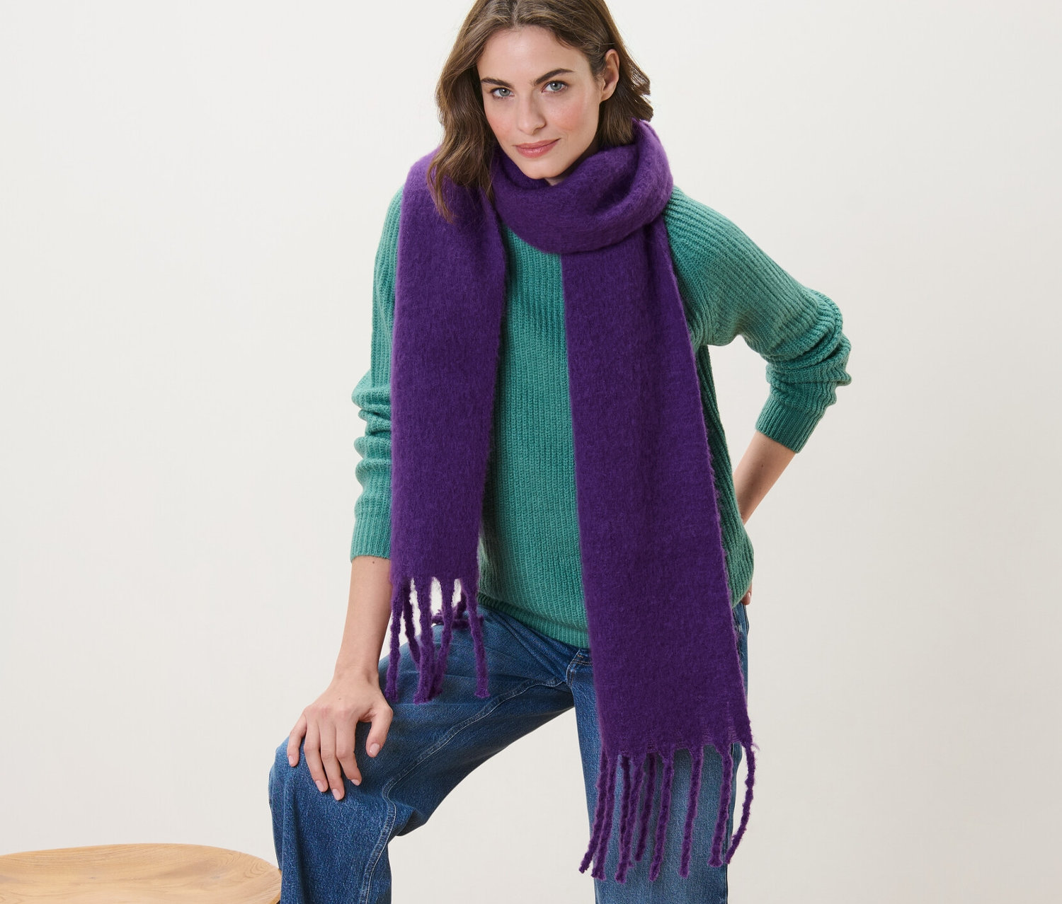 Kobieta pozuje w fioletowym tkanym szaliku.