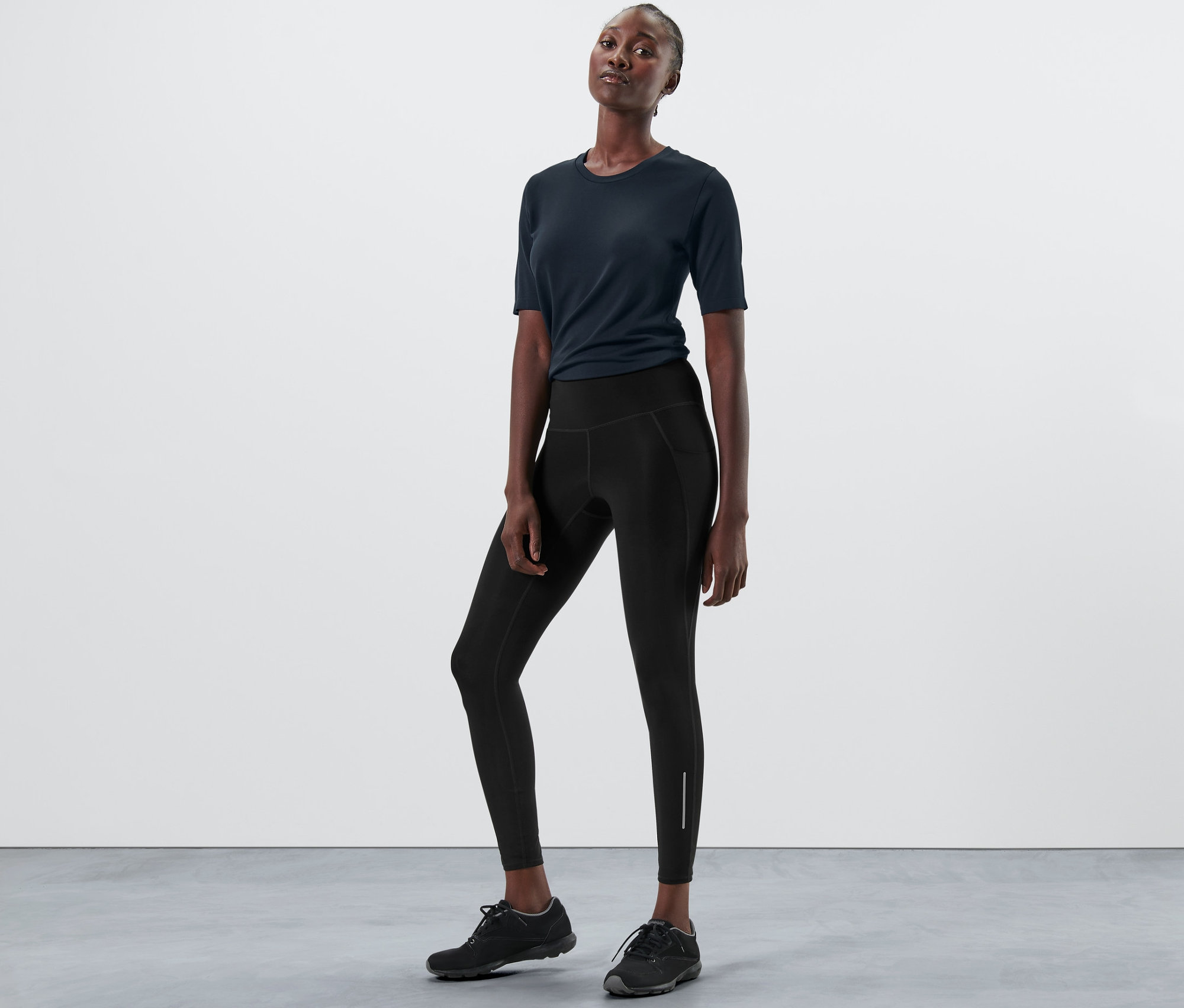 Kobieta pozuje w czarnych legginsach sportowych.