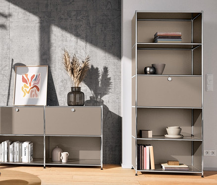 Wnętrze z fotelem obrotowym, okrągłymi stolikami kawowymi (60 cm i 80 cm), metalową lampą stojącą, chromowaną i metalową szafką typu highboard »CN3« z komorą z klapą.