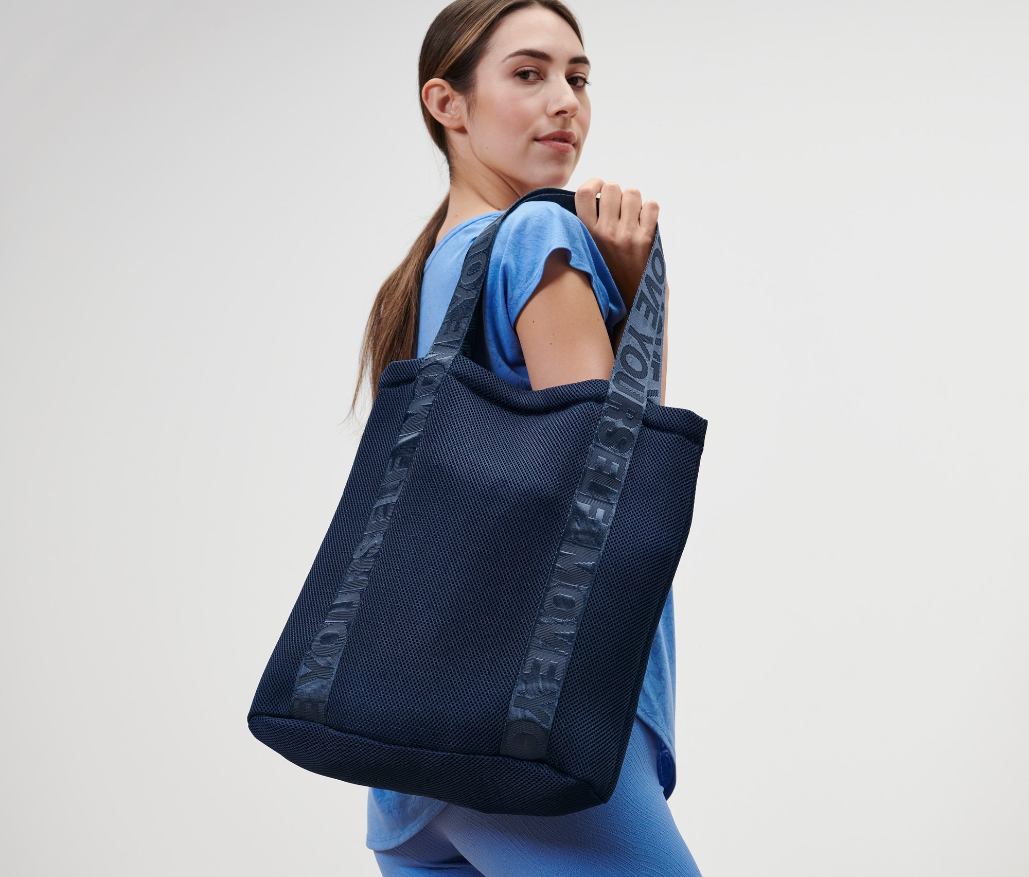 Kobieta trzyma torbę sportową.