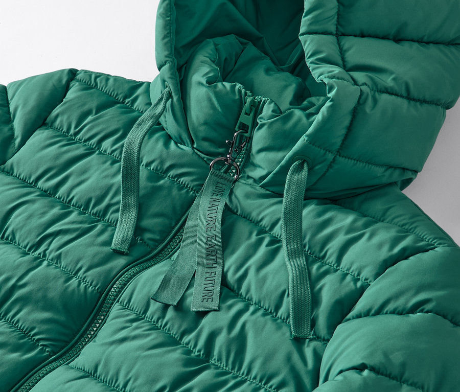 Zbliżenie na zielony pikowany płaszcz z kapturem.