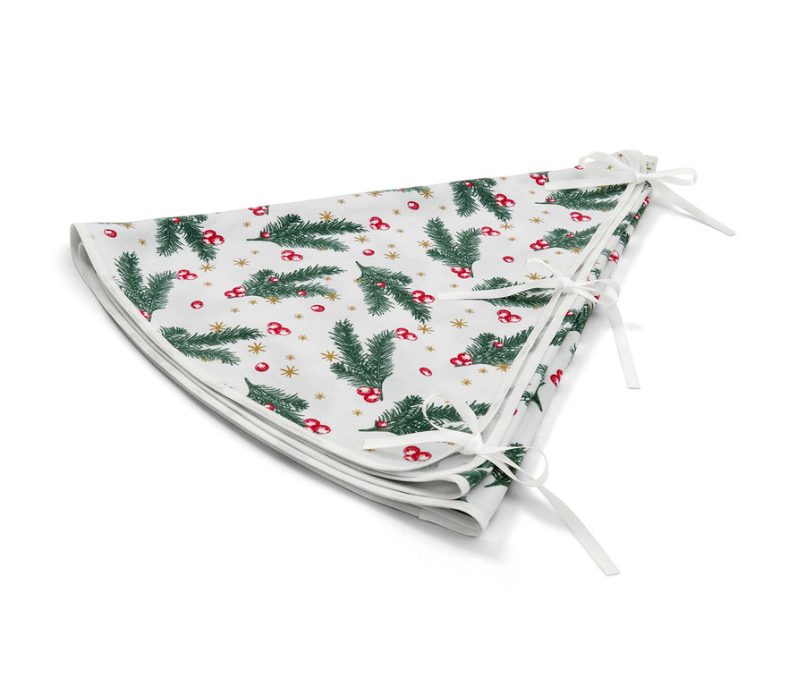 Biała serweta pod choinkę ze wzorem choinek, czerwonych jagód i złotych gwiazd.