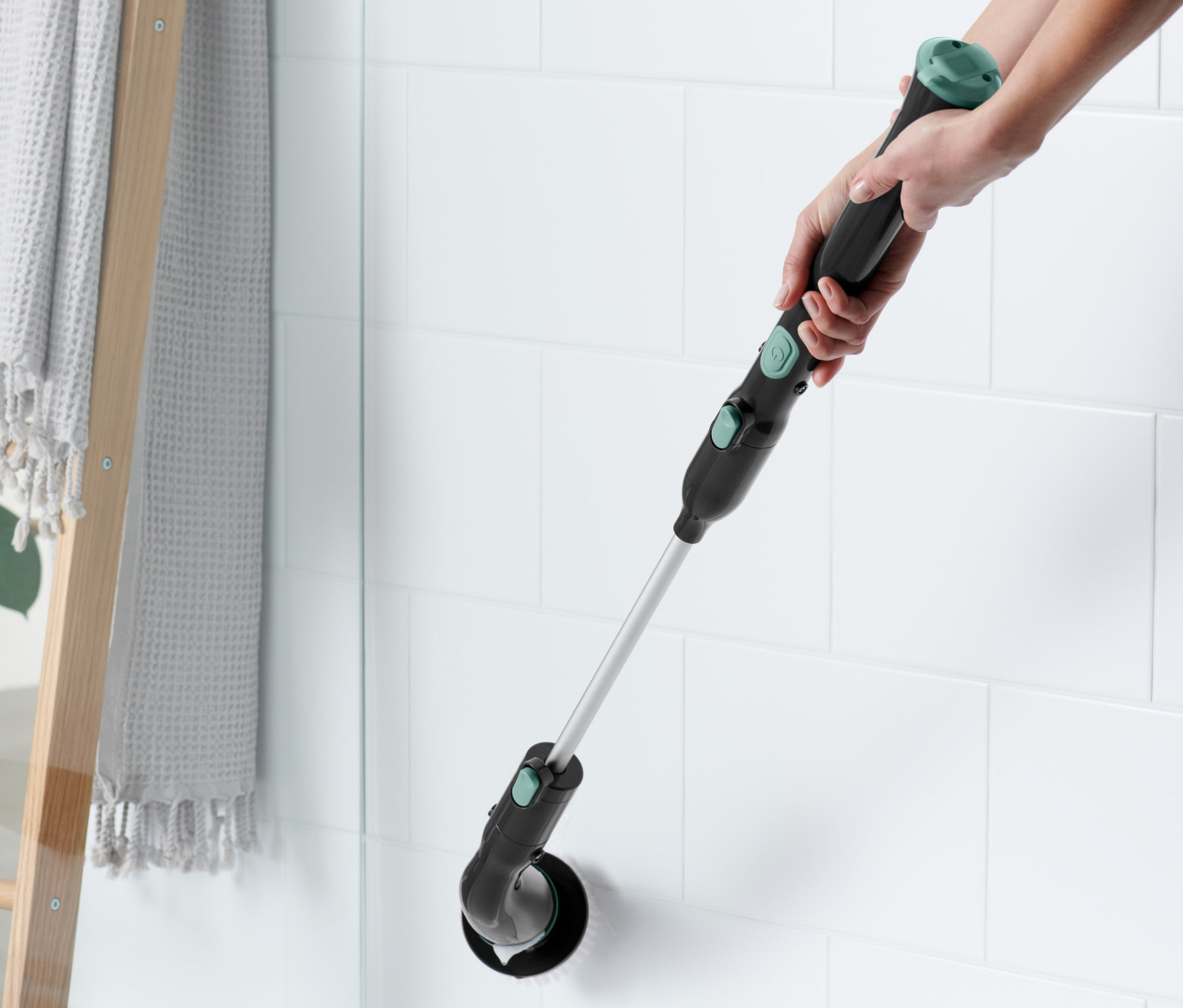 Kobieta czyści brzeg wanny elektryczną szczotką czyszczącą.