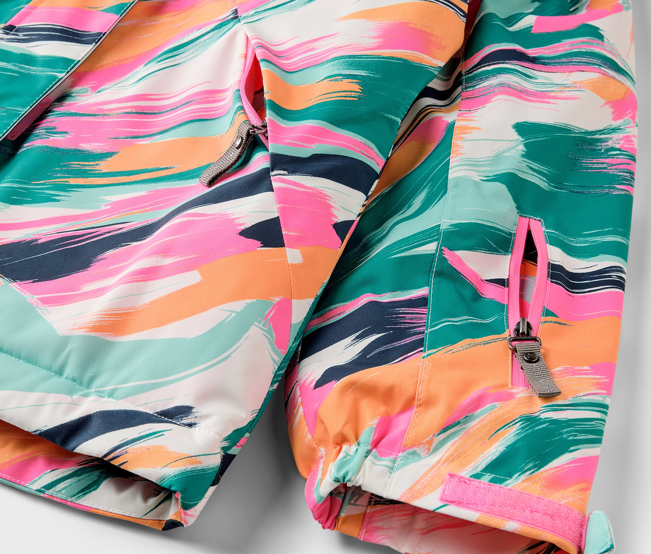 Fragment kolorowej kurtki z zamkiem błyskawicznym.