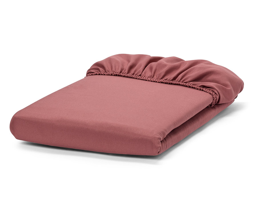 Złożone różowe prześcieradło z gumką.