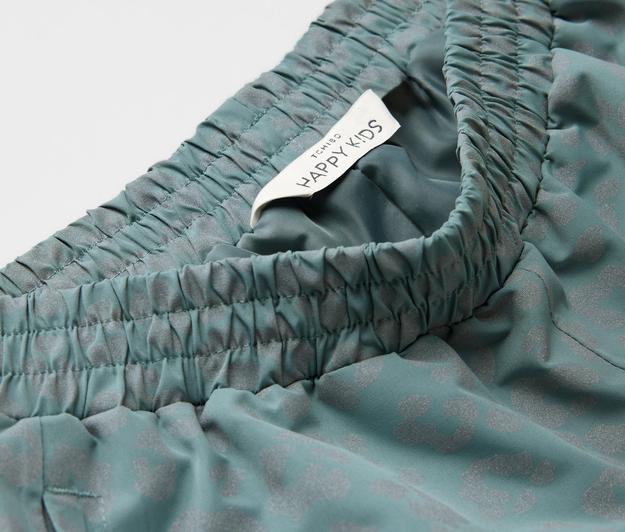 Zbliżenie na spodnie przeciwdeszczowe z elementami odblaskowymi.