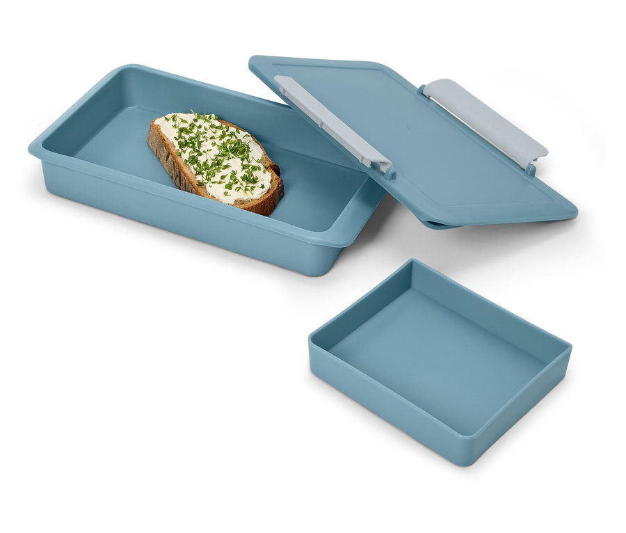 Kanapka z ziołami w niebieskim pudełku na lunch z pokrywką i puste niebieskie pudełko.