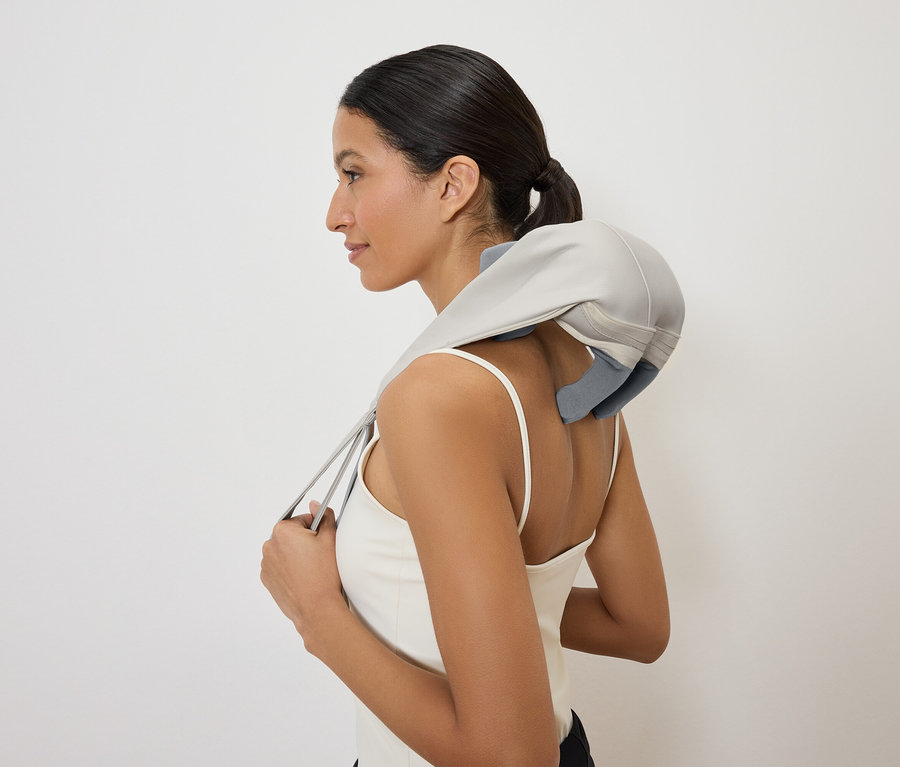 Kobieta z masażerem szyi, widok z boku.