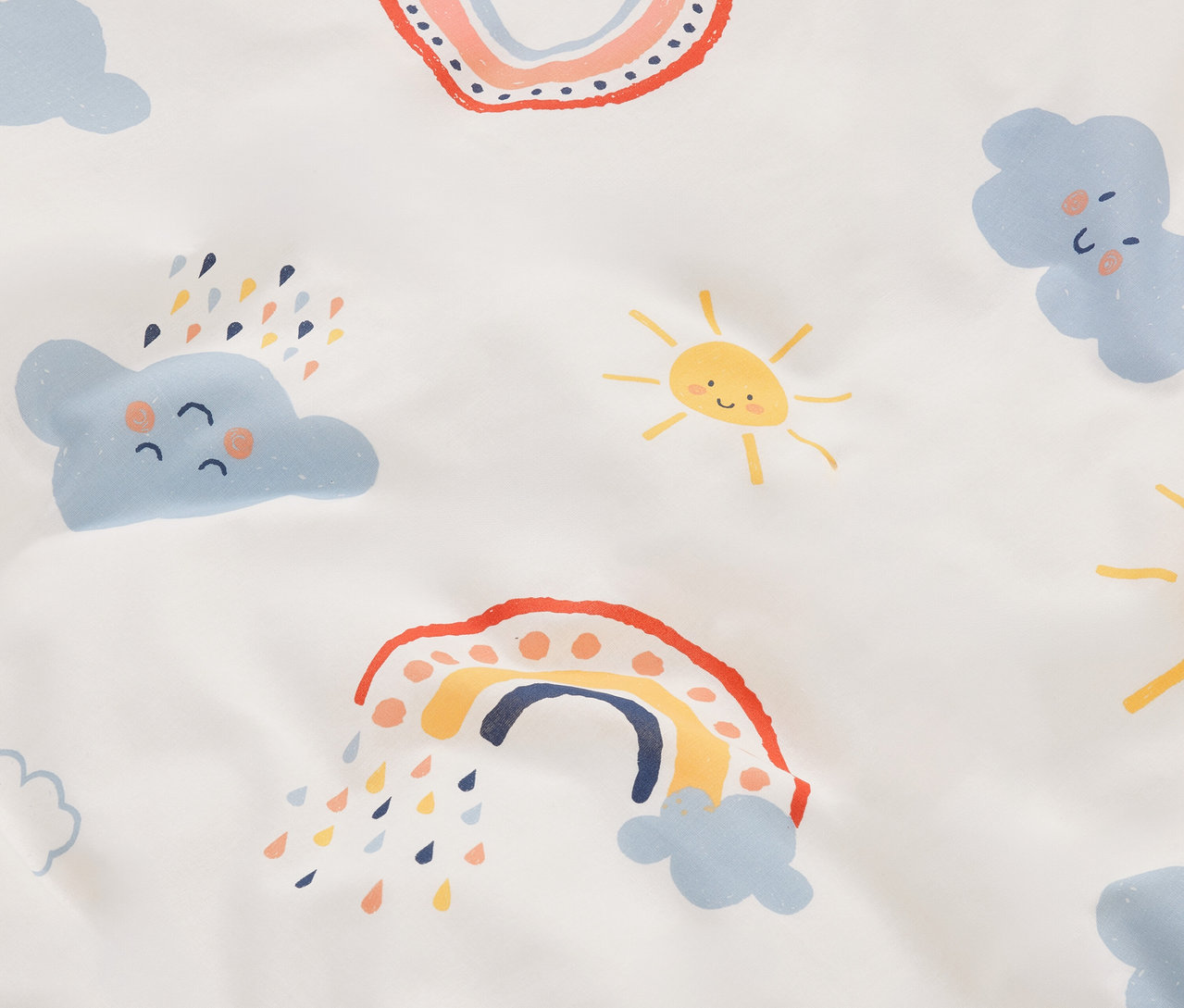 Zbliżenie tkaniny z kreskówkowymi tęczami, chmurami i słońcami na białym tle.