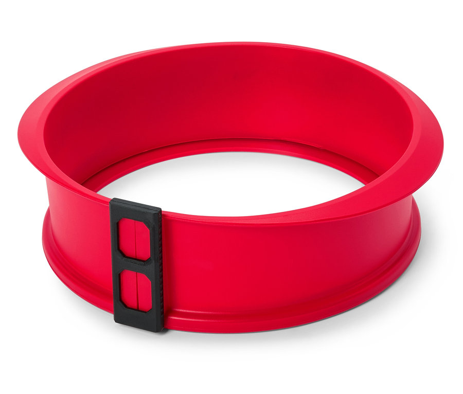 Czerwona, okrągła forma do pieczenia ciasta z czarnym zamknięciem na białym tle.