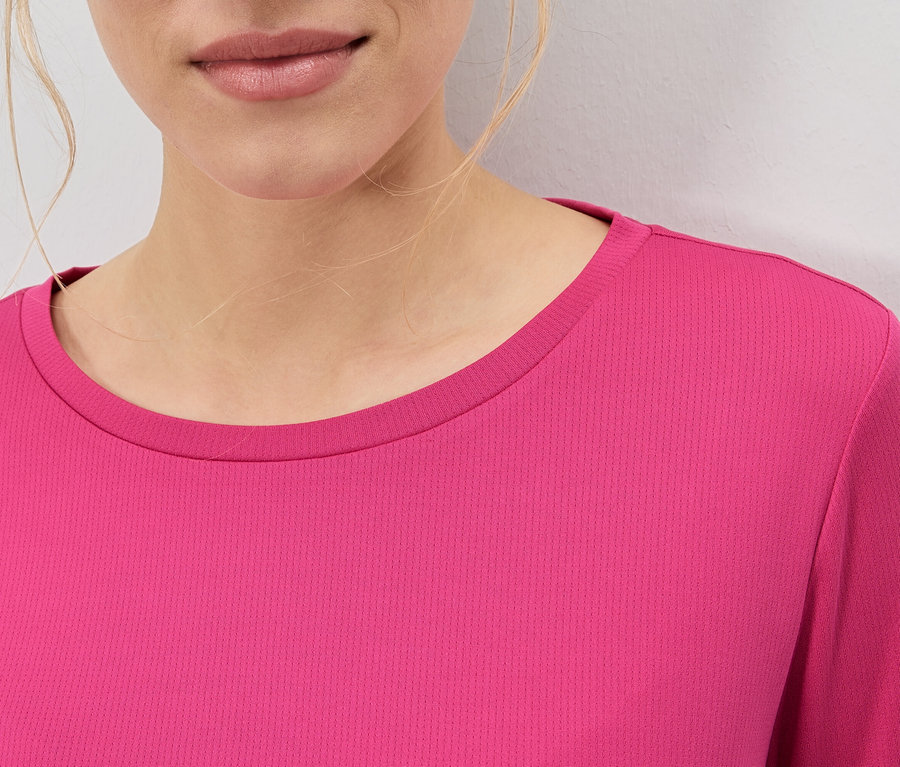 Zbliżenie kobiety ubranej w różową bluzkę.