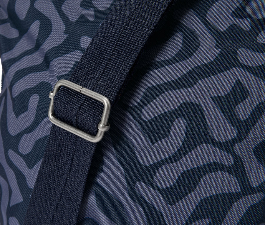 Zbliżenie torby z niebieskim wzorem i srebrnym zapięciem na pasku.