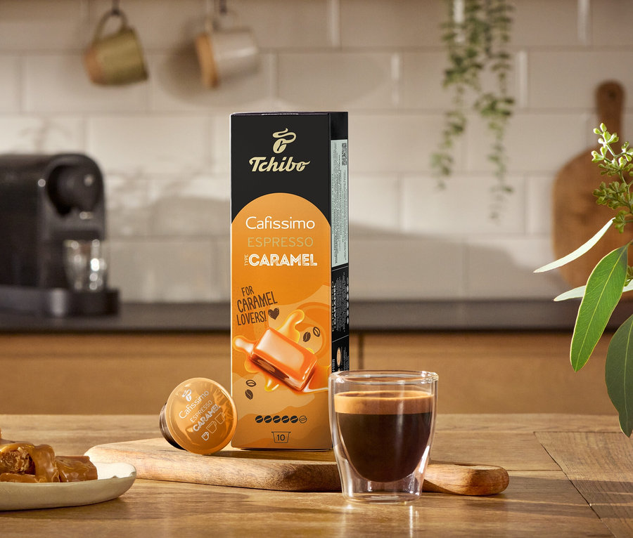 Espresso, karmelki i opakowanie Flavoured Edition: Espresso Caramel – 80 kapsułek na drewnianym stole.