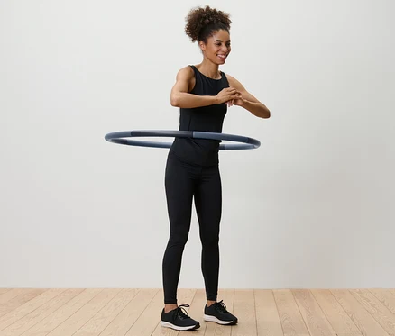 Kobieta kręci obręczą do fitness wokół talii.
